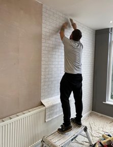Decorator fitting wallpaper with faux brick pattern